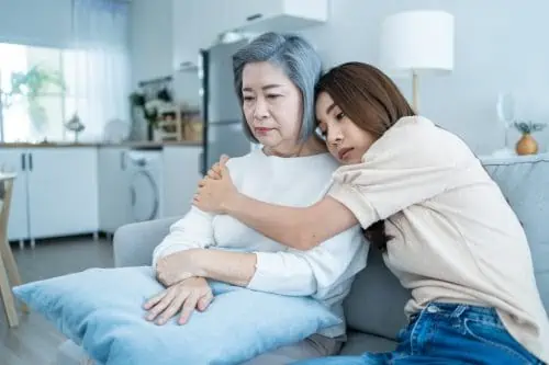 Asian loving daughter comforts upset elderly mother crying for problem. Young caring woman support, consoling and understand empathy to stressed senior older mom in tears at home. Family relationship.