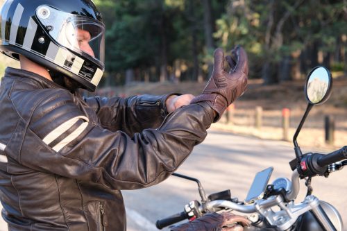 Biker puts on gloves before riding on motorcycle