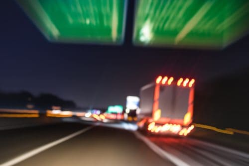 Defocused blurred motion of semitruck speeding on highway road speedway