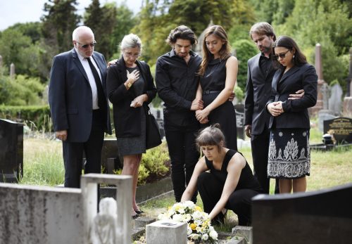 Family laying flowers on the grave