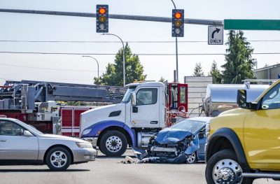 Intersection accident involving a car and a big rig semi truck with tank semi trailer