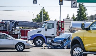 Intersection accident involving a car and a big rig semi truck with tank semi trailer