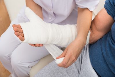 Close-up Of A Nurse Dressing Patient's Hand With Bandage