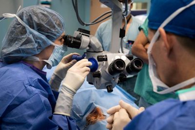Ophthalmologist examines a patient's eye during pterygium surgery, a corneal growth removal