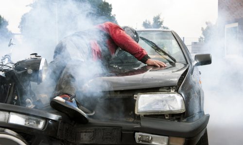 Severe accident between a motorcyclist and a car, injuring both drivers and causing a lot of damage