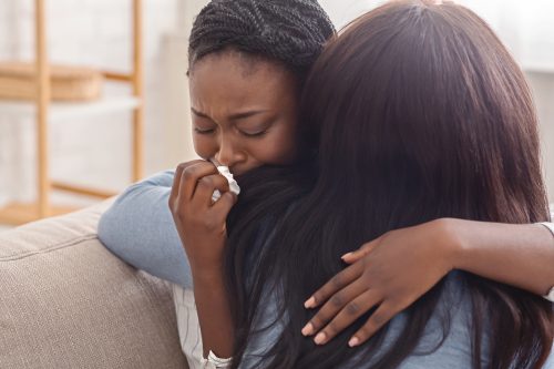 Woman hugging her crying girlfriend, supporting her after receiving bad news