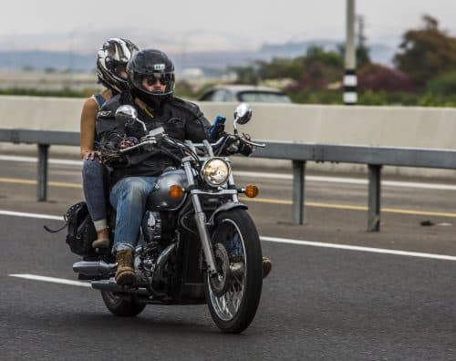 man riding a motorcycle with a passenger