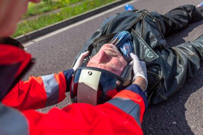 paramedic removes an helmet from an injured biker