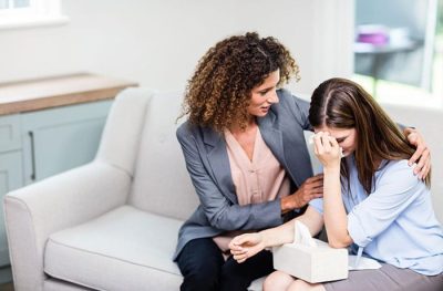 Woman comforting crying young girl