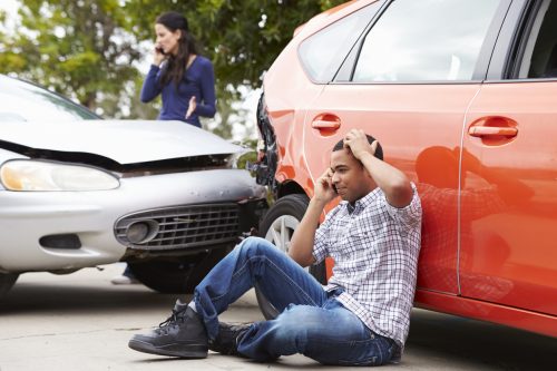 Male Driver Making Phone Call After Traffic Accident Holding Head In Hands