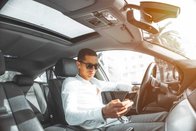 Man in white dress shirt texting while driving