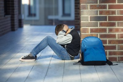 schoolboy crying in the hallway of the school