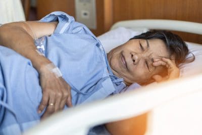 elderly senior aged patient hospitalized on bed in hospital for medical geriatic care and treatment