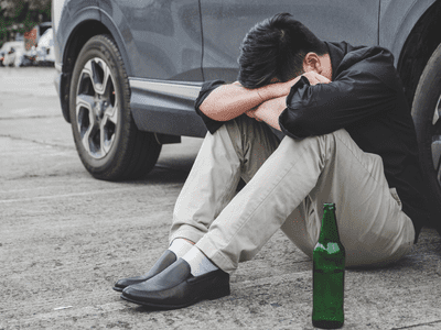 sitting outside a car with a beer