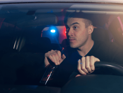 man drinking a beer while driving