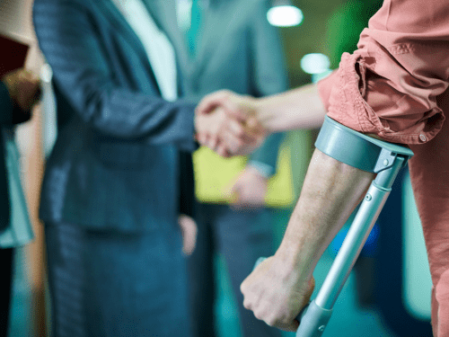 a man on crutches shaking his lawyers hand