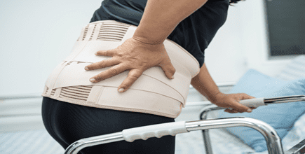 woman using a walker grabbing her back