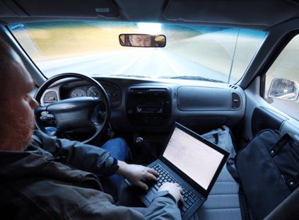 man on his laptop while driving
