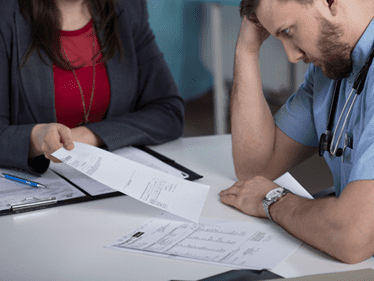 doctor being handed paperwork from a lawyer