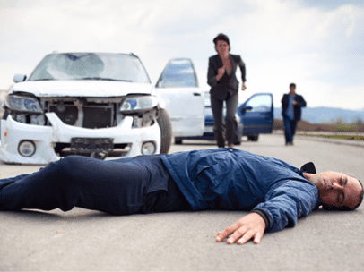 man lying on the ground after being hit by a car