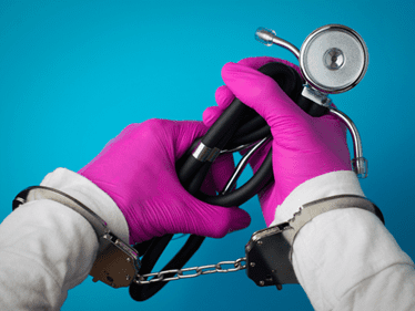 doctor in handcuffs holding a stethoscope