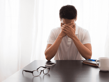 distressed man with hands over his face