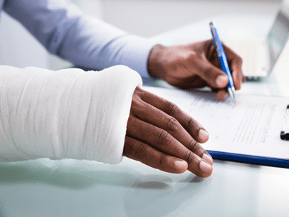 man with broken hand filling out paperwork