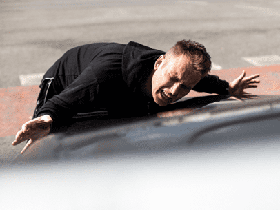 man on the hood of a car after being struck by a car