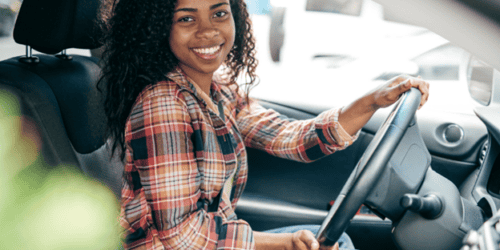 Teen driver holding the steering wheel and going the speed limit